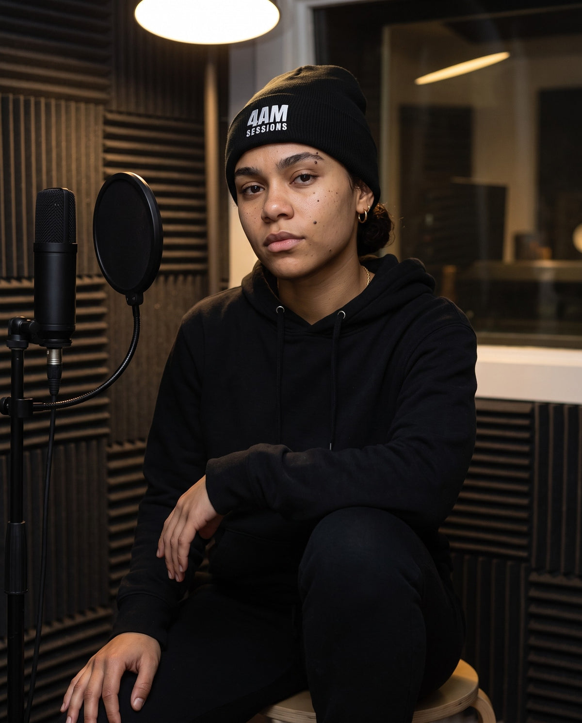 Model wearing the 4AM Sessions beanie in Black in a vocal booth
