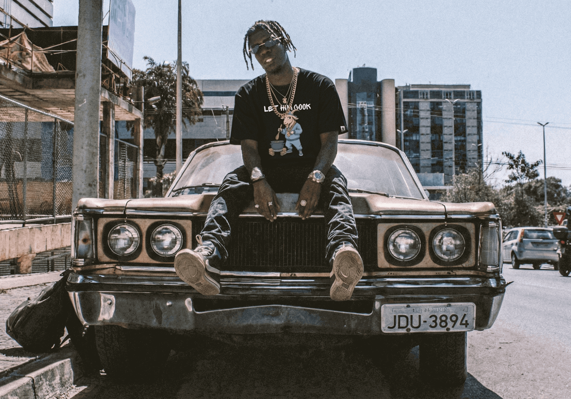 Person sitting on a vintage car with urban background