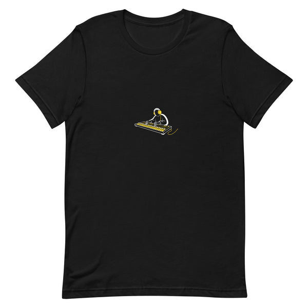 Black t-shirt with a white-and-yellow illustration of an audio engineer at a mixing board — Ghostnote streetwear tee, flat front