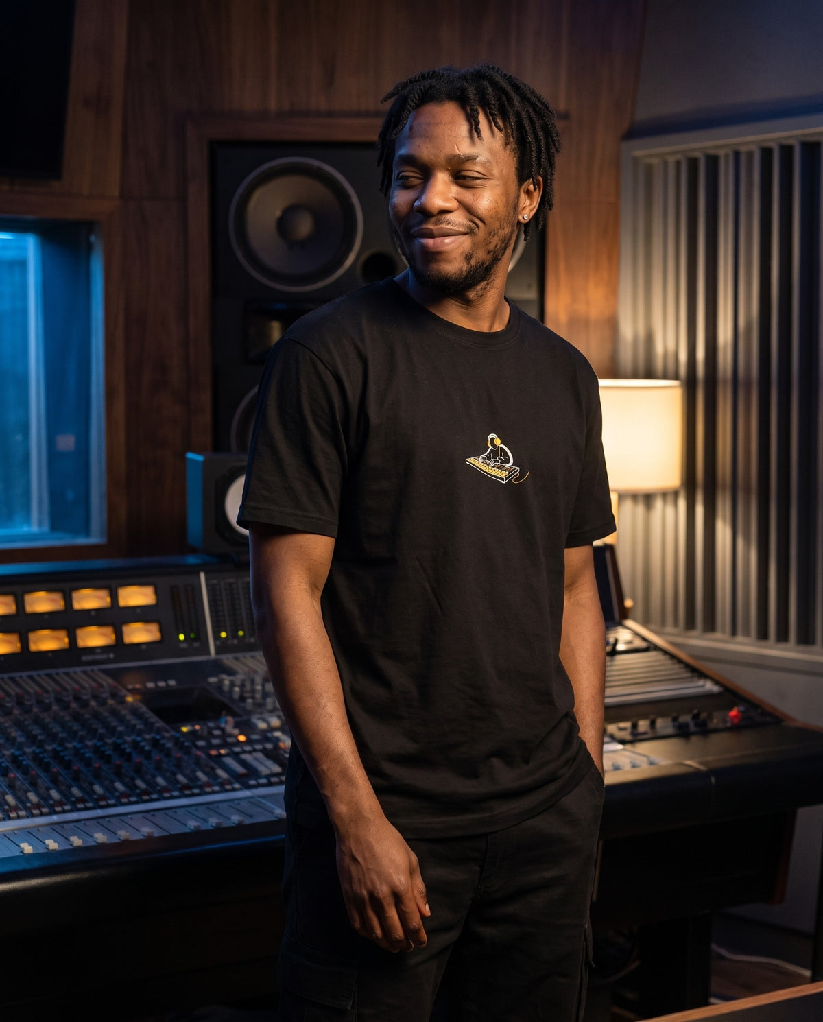 Model wearing the Behind The Board t-shirt in Black, in a recording studio control room