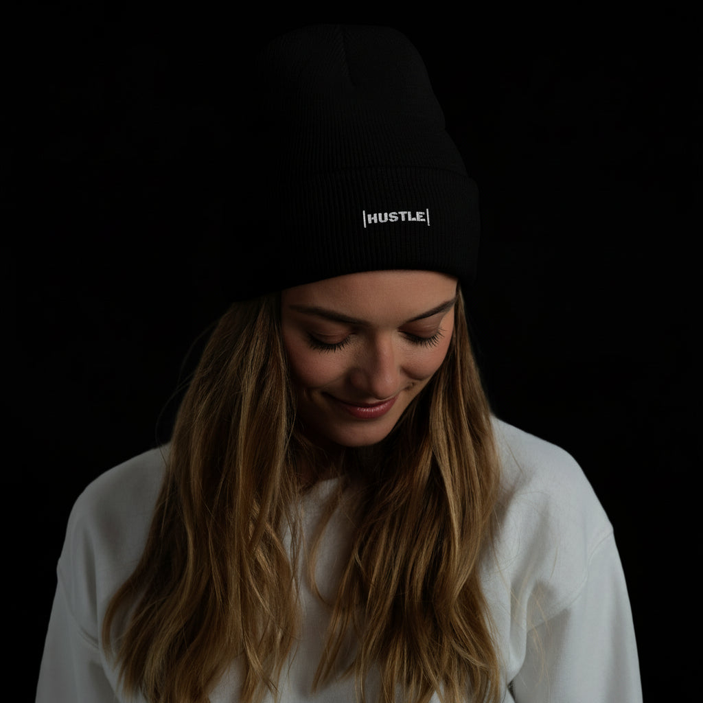 Woman wearing a black beanie with 'HUSTLE' text