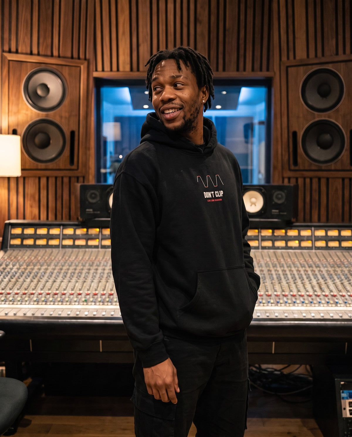 Model wearing the Don't Clip hoodie in Black, in a recording studio control room