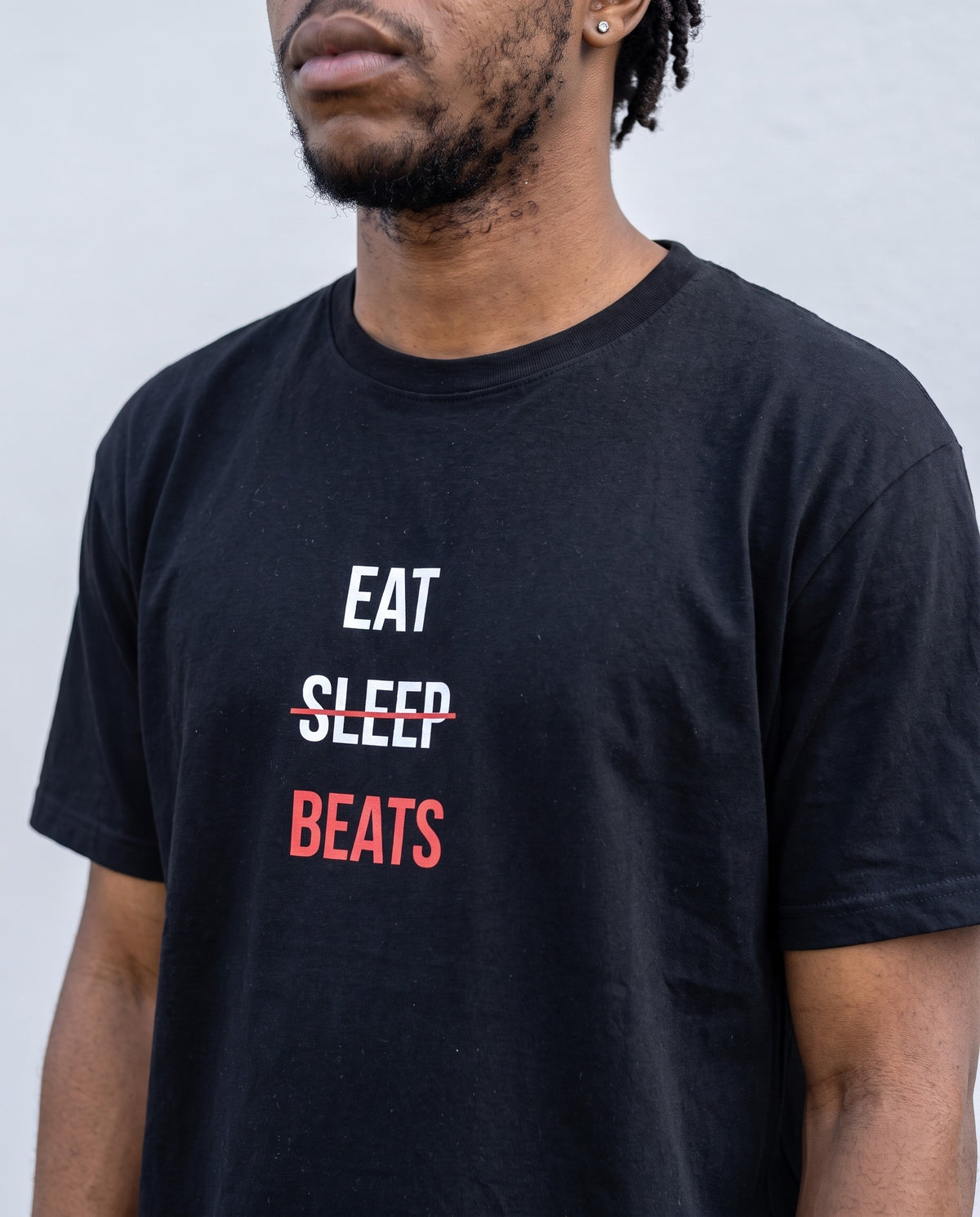 Model wearing the Eat Sleep Beats t-shirt in Black, print close-up
