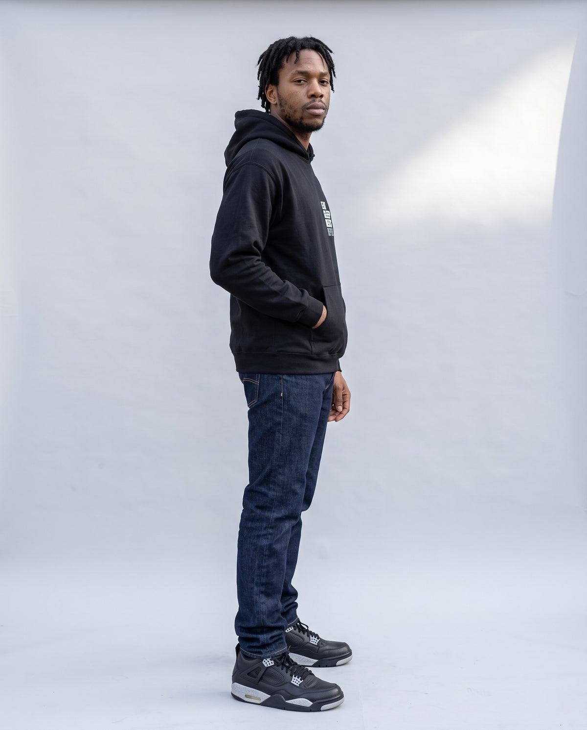 Model wearing the Eat Sleep Beats Repeat hoodie in Black, side profile