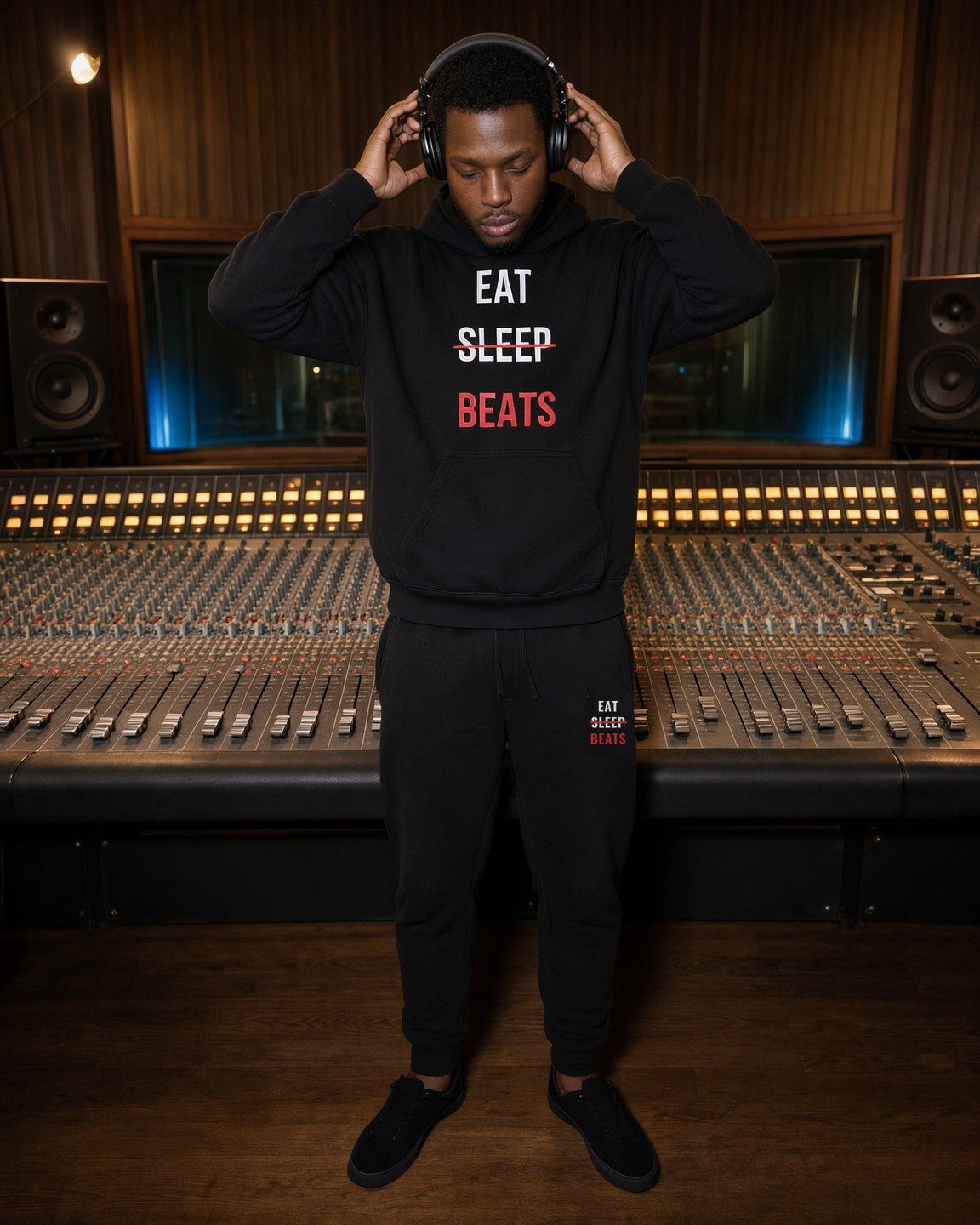 Model wearing the Eat Sleep Beats Embroidered Sweatpants in Black with the matching hoodie, studio