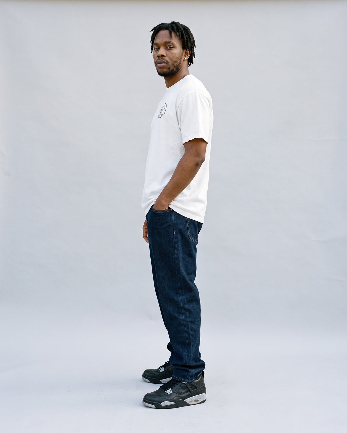 Model wearing the Ghostnote Premium Heavyweight Tee (Light Colors) in White, side profile