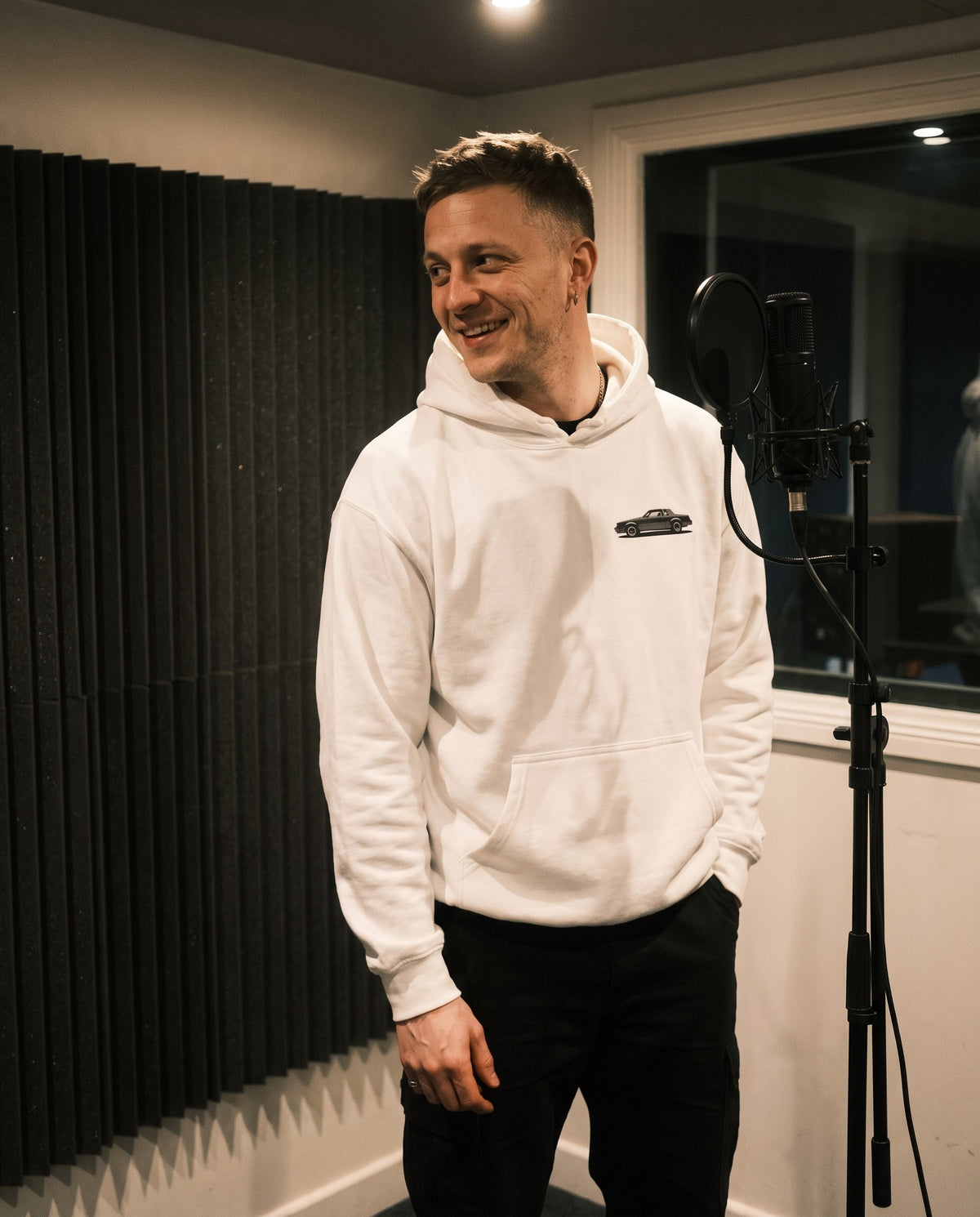 Model wearing the GNX Inspired Hoodie in White, in a vocal booth