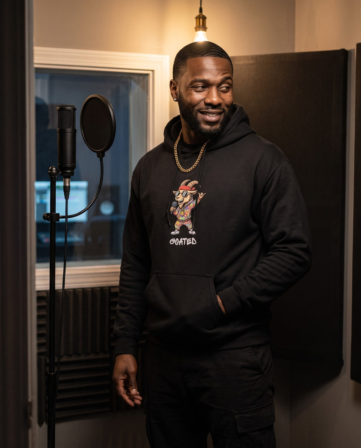 Model wearing the Goated hoodie in Black, in a vocal booth