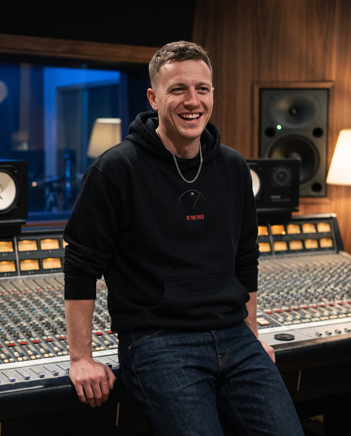 Model wearing the In The Red hoodie in Black, in a recording studio control room