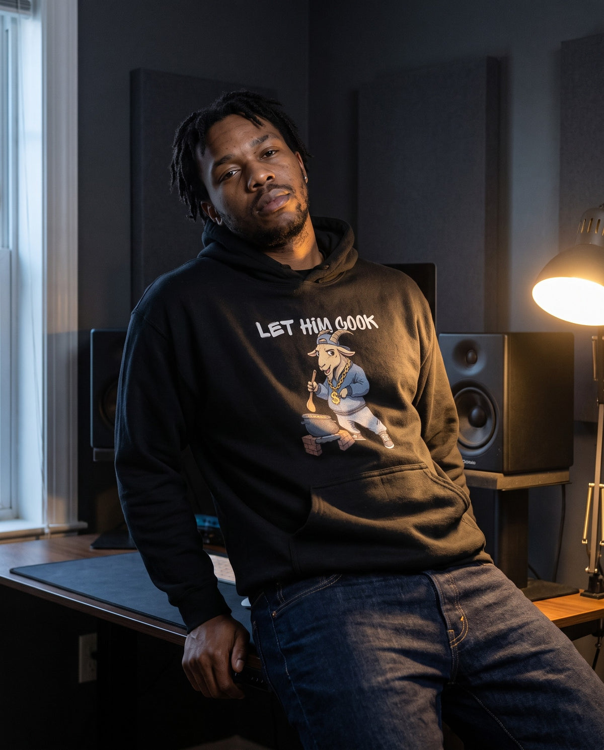 Model wearing the Let Him Cook hoodie in Black, in a home studio