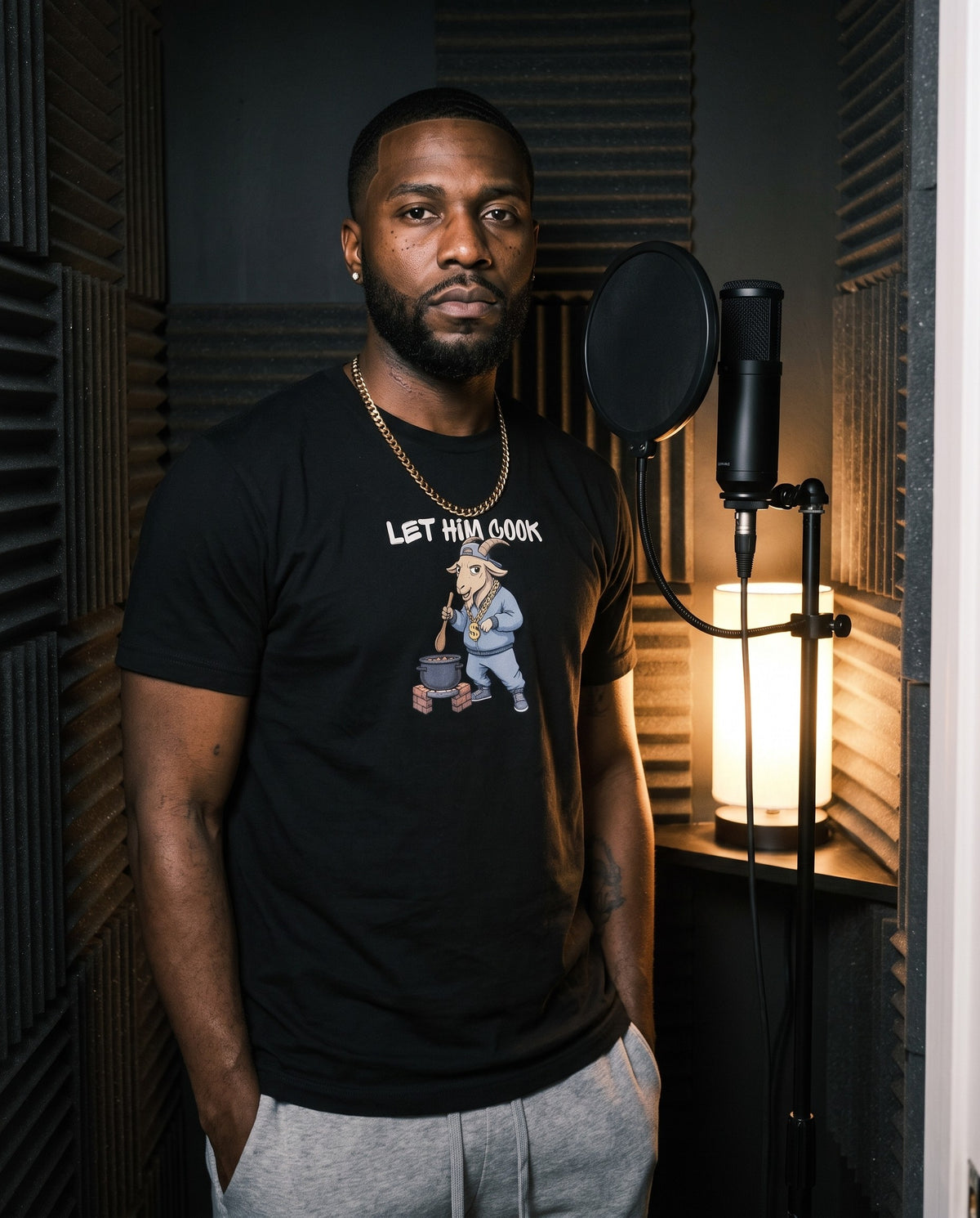 Model wearing the Let Him Cook t-shirt in Black, in a vocal booth