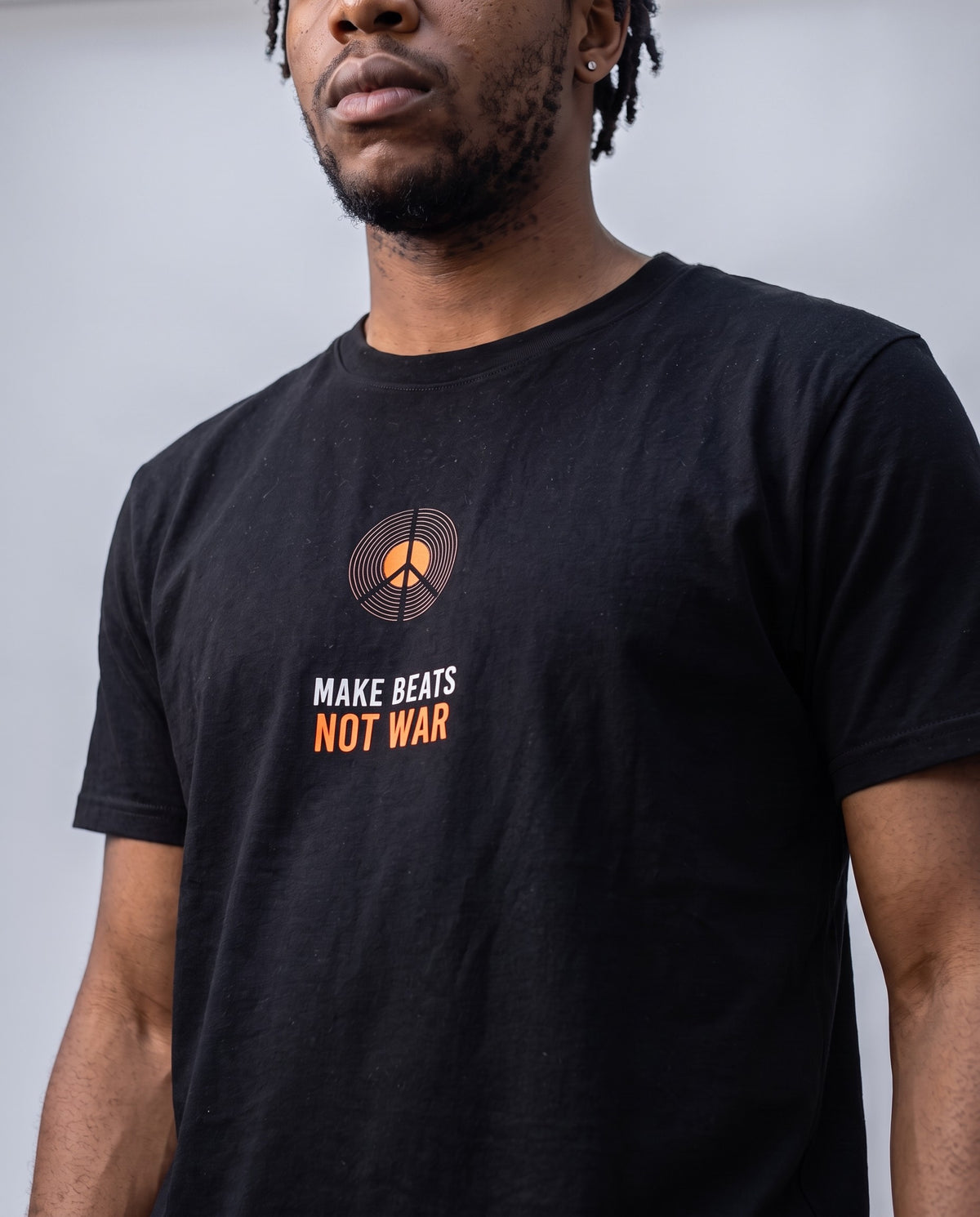 Model wearing the Make Beats Not War t-shirt in Black, print close-up