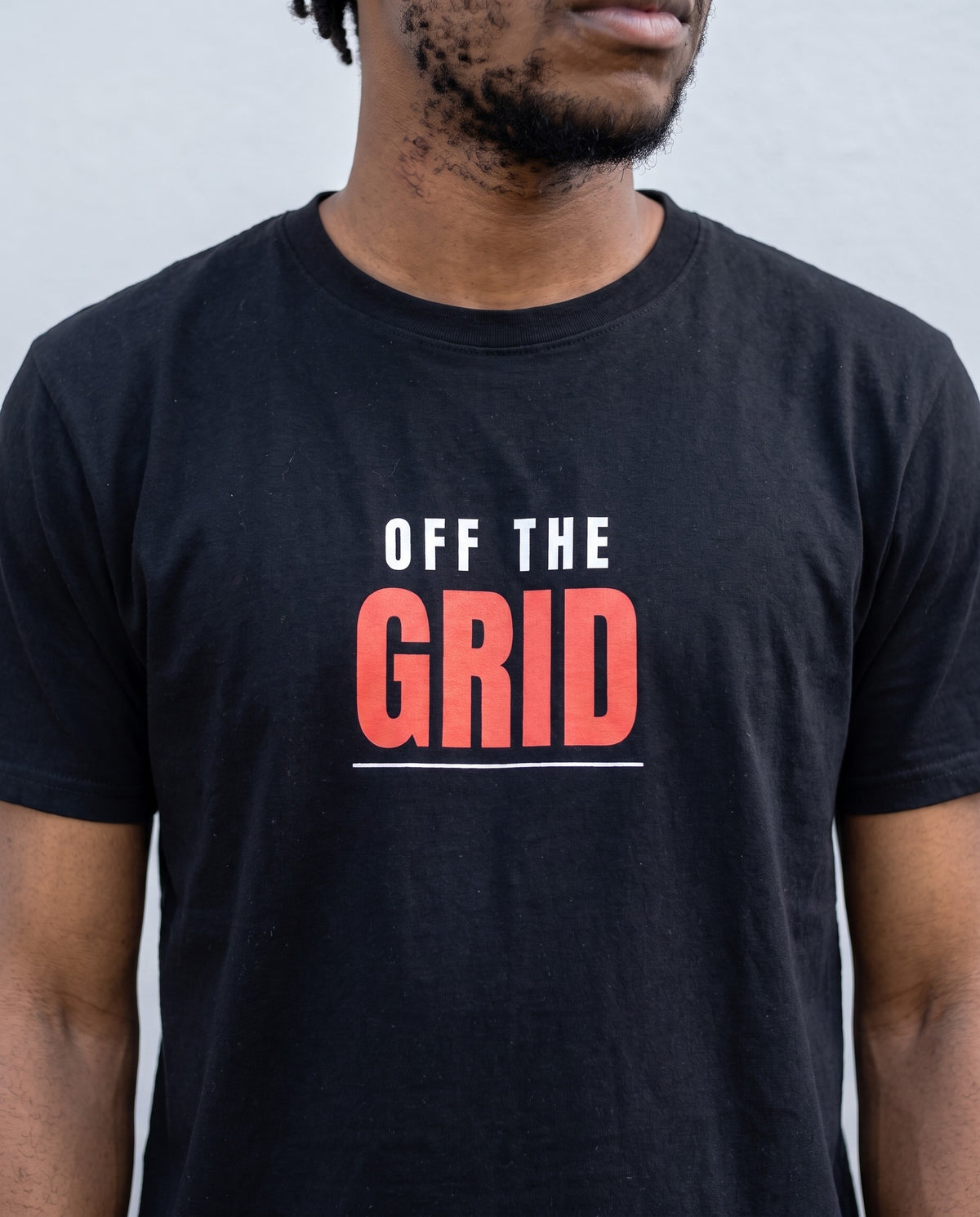Model wearing the Off The Grid t-shirt in Black, print close-up