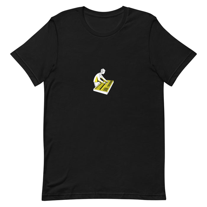 Black t-shirt with a white-and-yellow illustration of an audio engineer working at a mixing console — Ghostnote streetwear tee, flat front