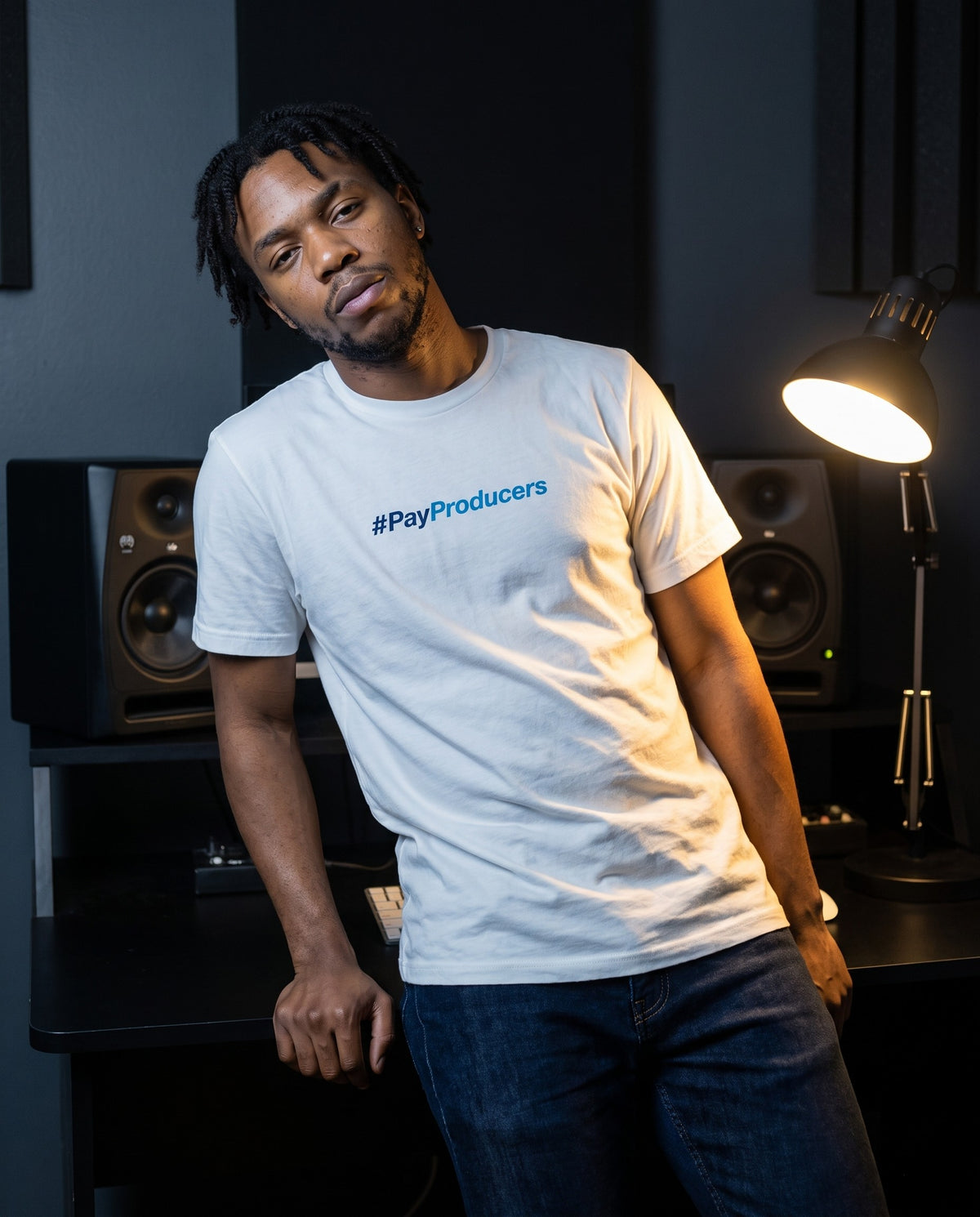 Model wearing the Pay Producer t-shirt in White, in a home studio