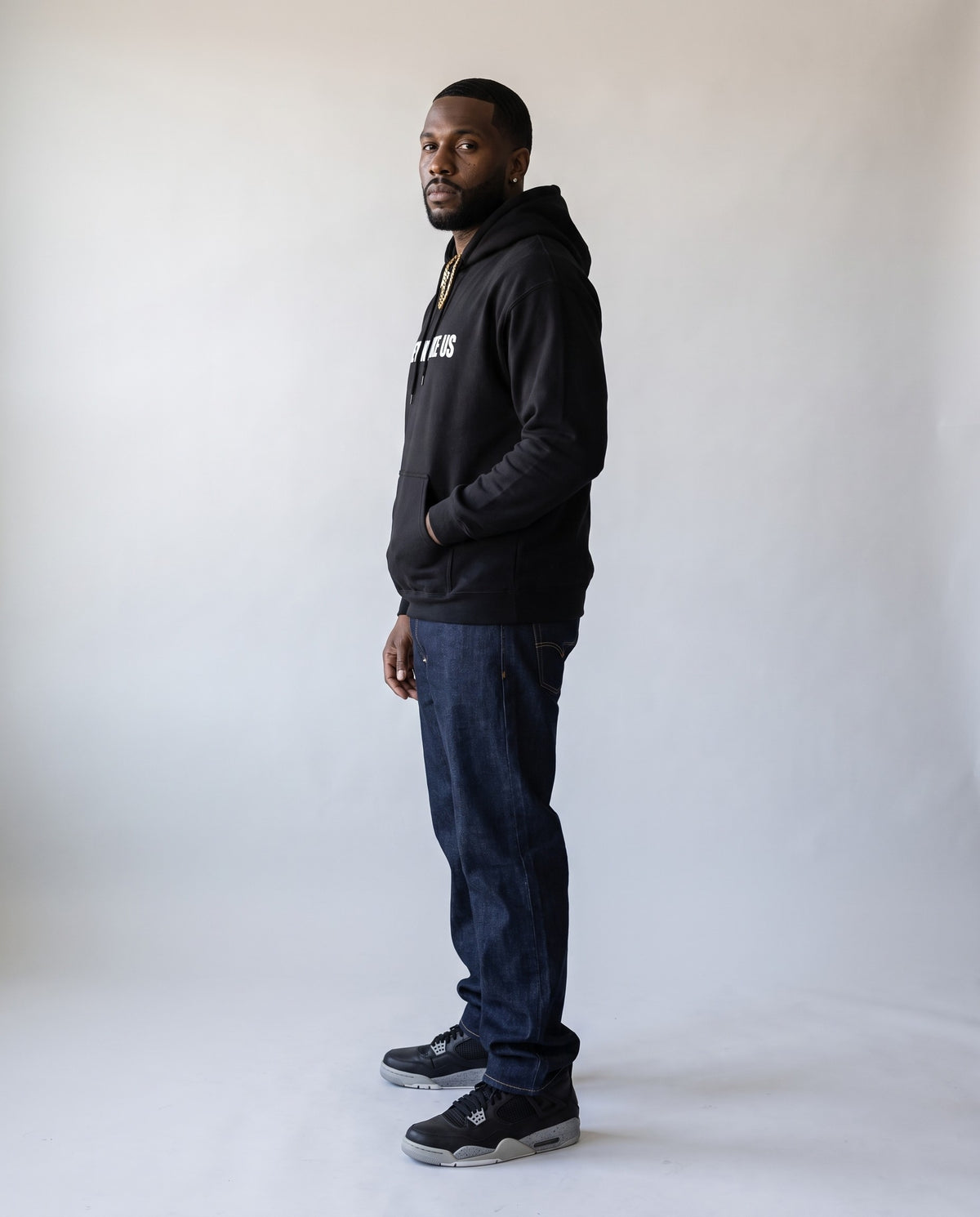 Model wearing the They Not Like Us Rapper Hoodie in Black, side profile