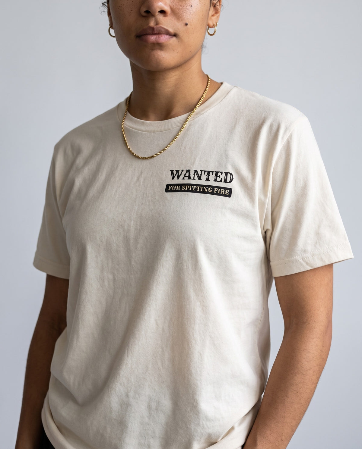 Model wearing the Wanted For Spitting Fire t-shirt in Beige, print close-up