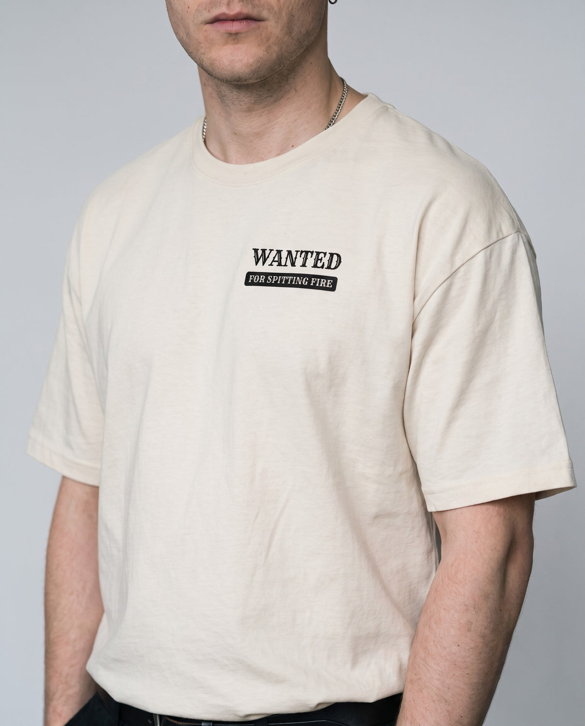 Model wearing the Wanted For Spitting Fire t-shirt in Beige, print close-up