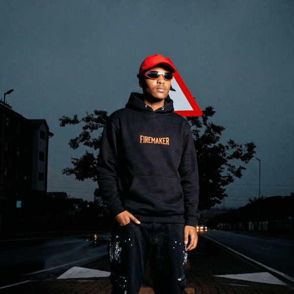 Rapper wearing a black Ghostnote Firemaker hoodie on the street