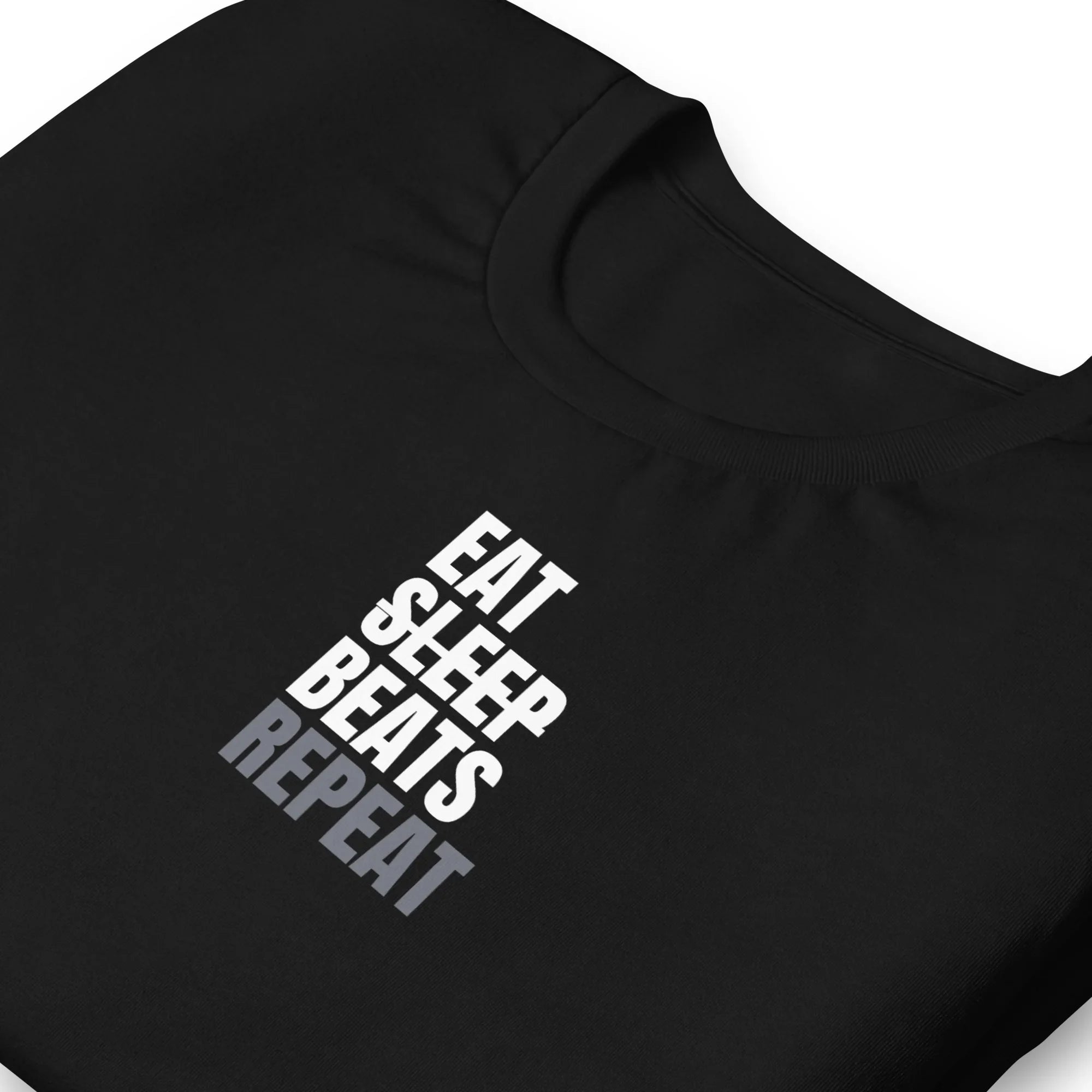 Black folded music producer t-shirt with 'Eat Sleep Beats Repeat' text on a black background.