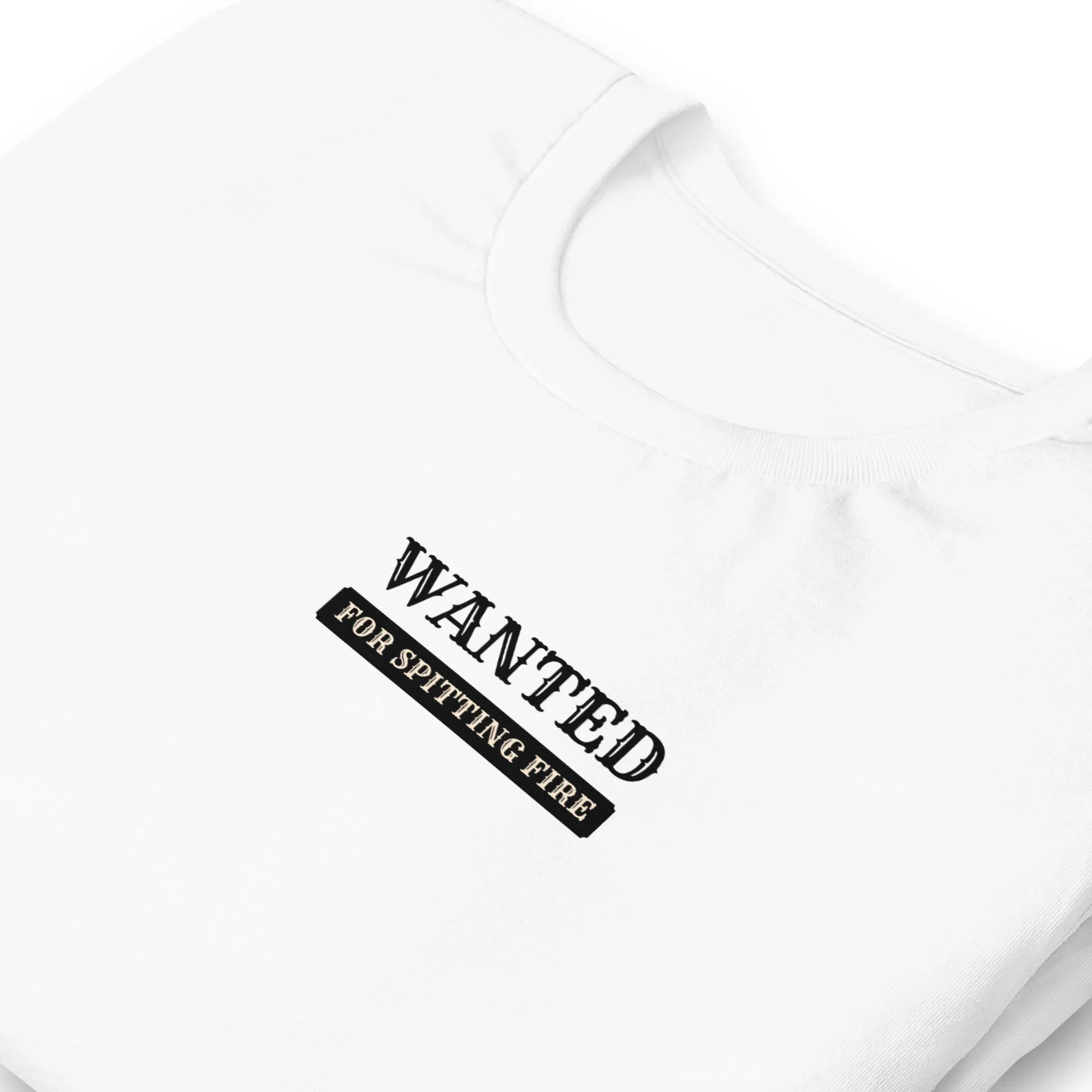 White folded t-shirt with 'WANTED' text on a white background