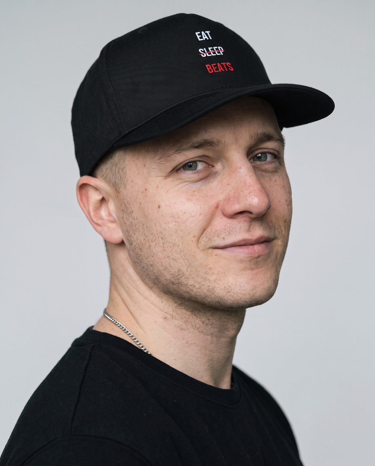 Model wearing the Eat Sleep Beats Cap in Black, head and shoulders