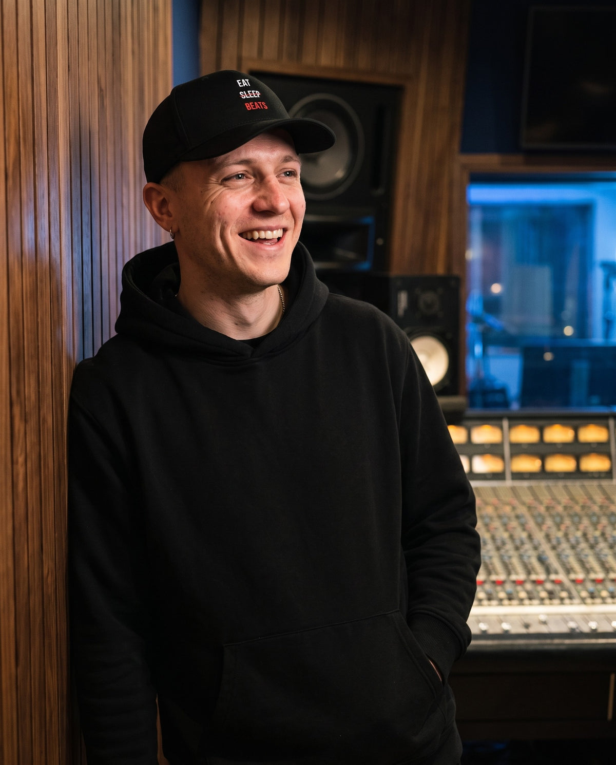 Model wearing the Eat Sleep Beats Cap in Black, in a recording studio