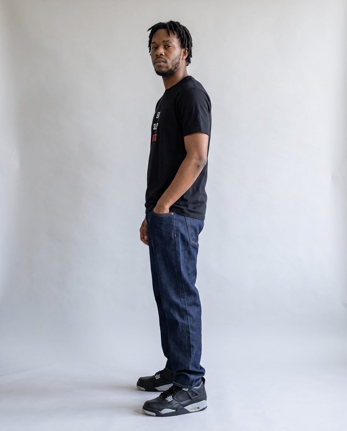 Model wearing the Eat Sleep Beats t-shirt in Black, side profile