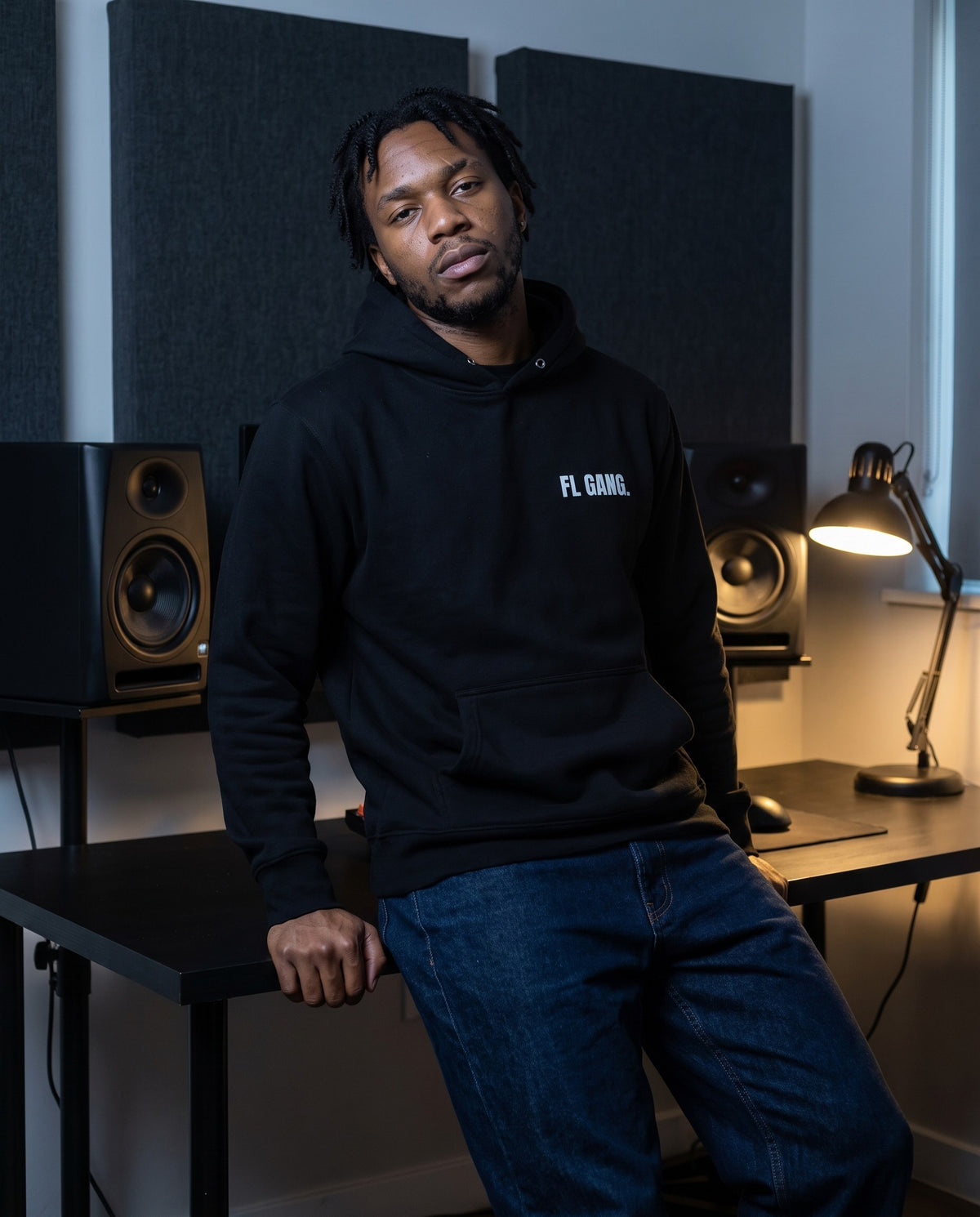Model wearing the FL Gang Premium Hoodie in Black, in a home studio