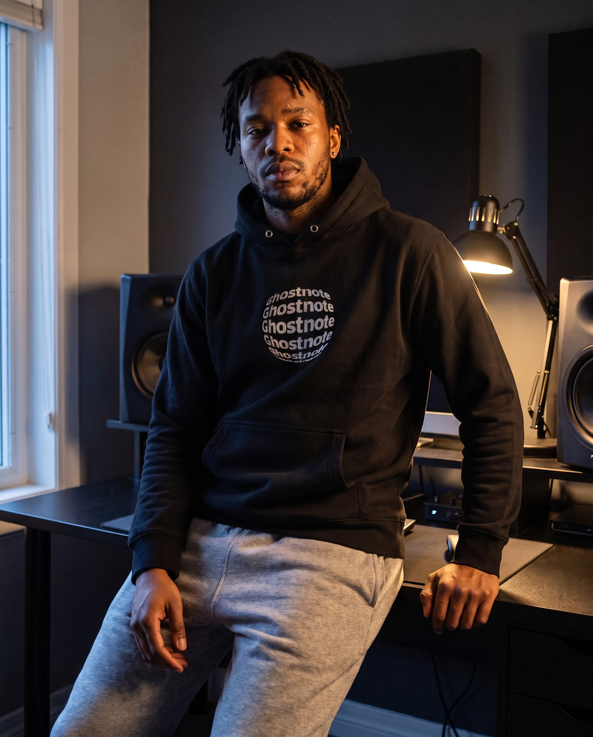 Model wearing the Ghostnote Alternative hoodie in Black, in a home studio
