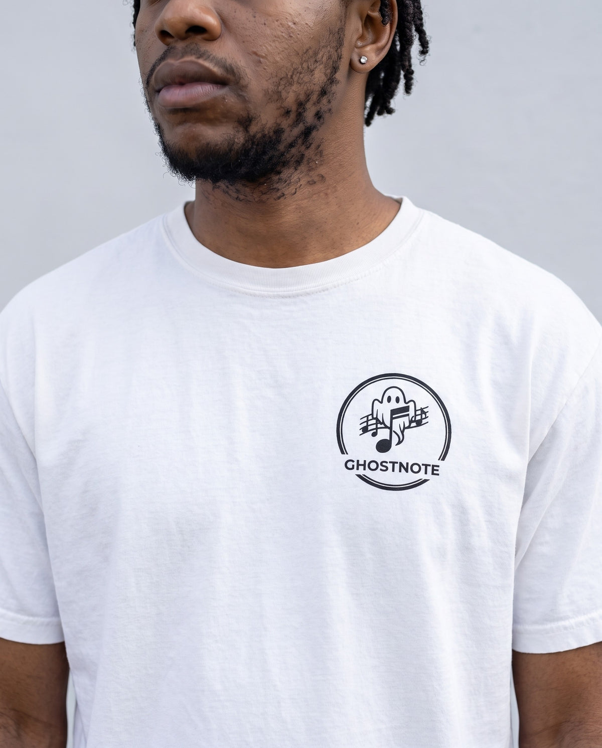 Model wearing the Ghostnote Premium Heavyweight Tee (Light Colors) in White, print close-up