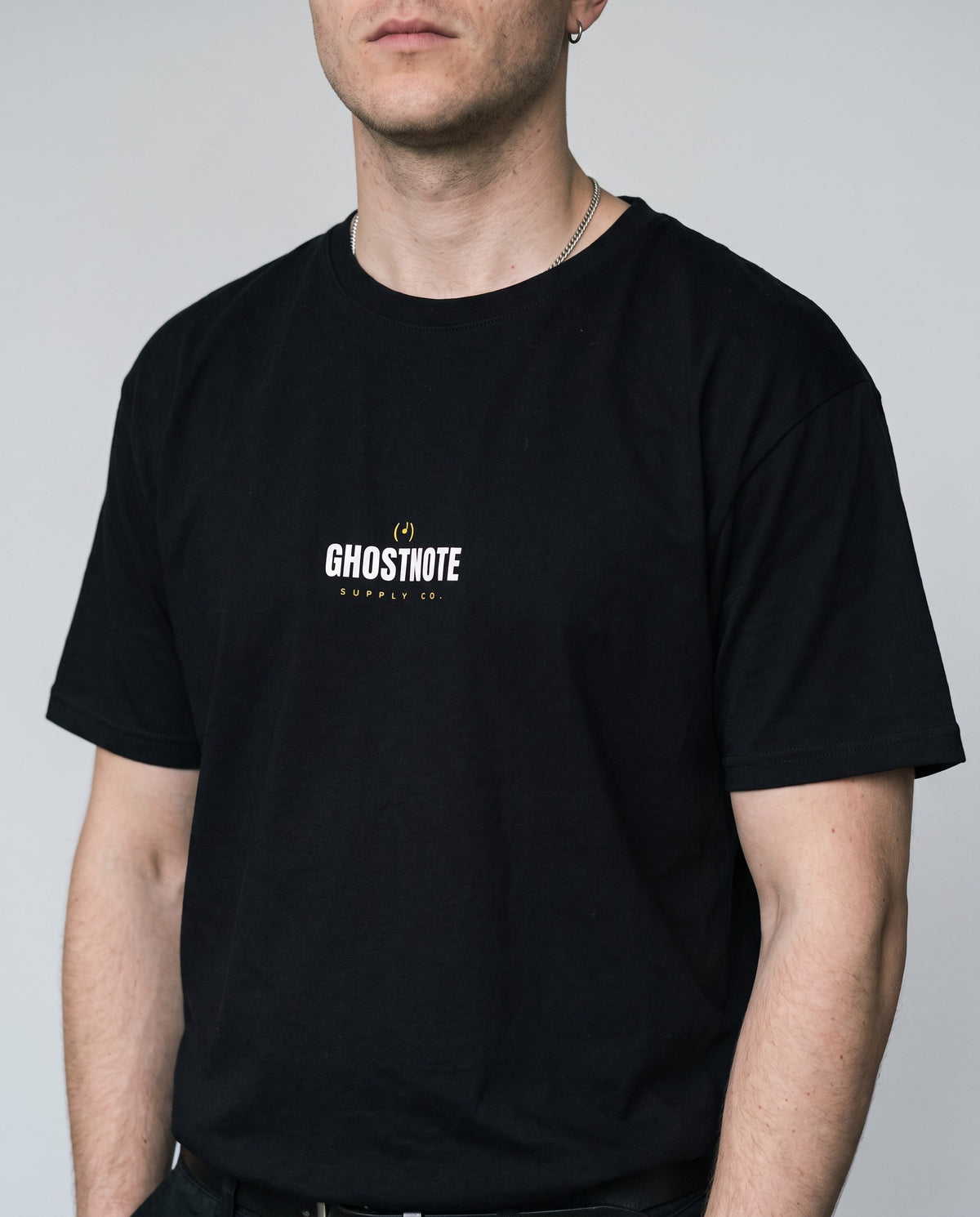 Model wearing the Ghostnote Wordmark t-shirt in Black, print close-up