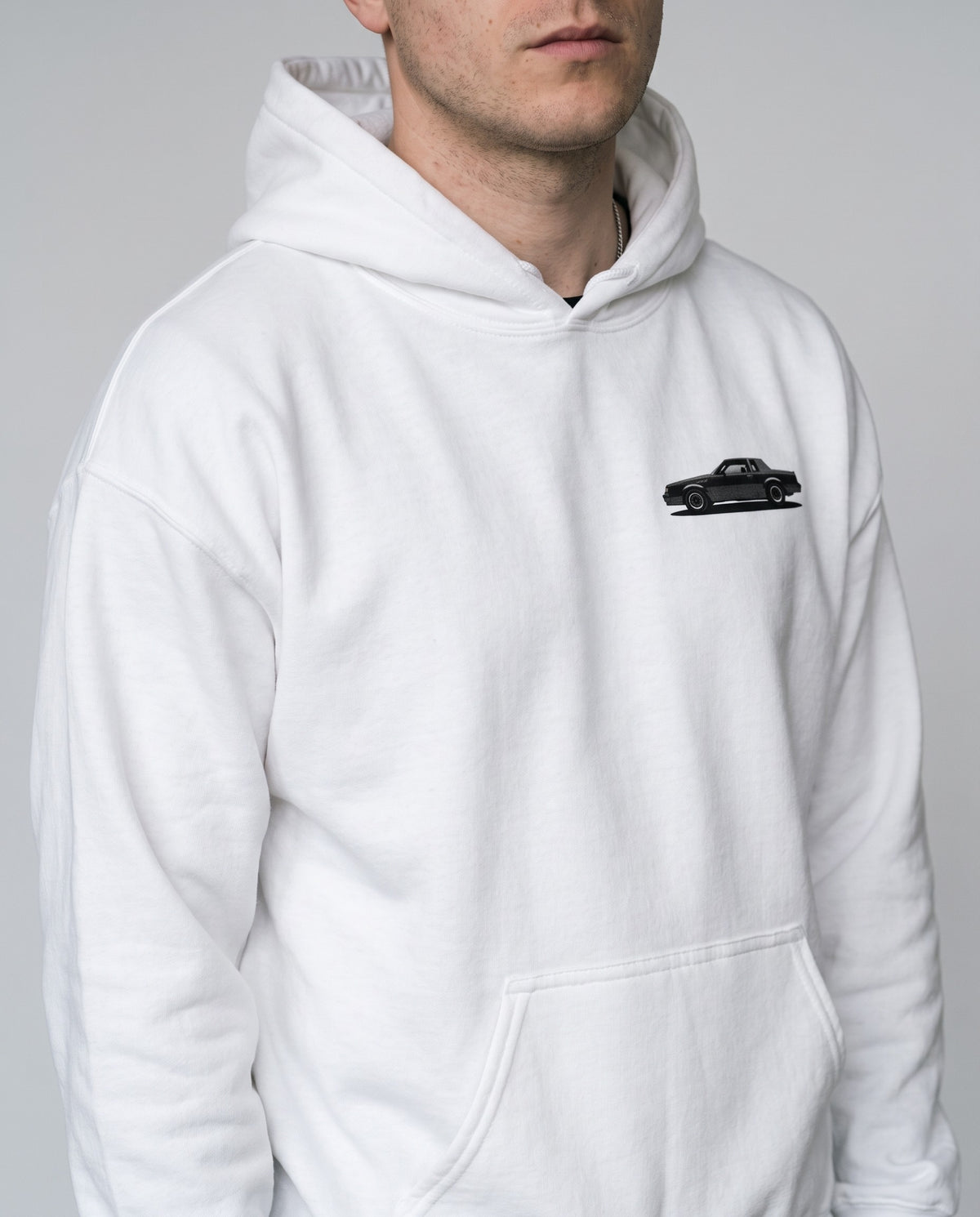 Model wearing the GNX Inspired Hoodie in White, print close-up