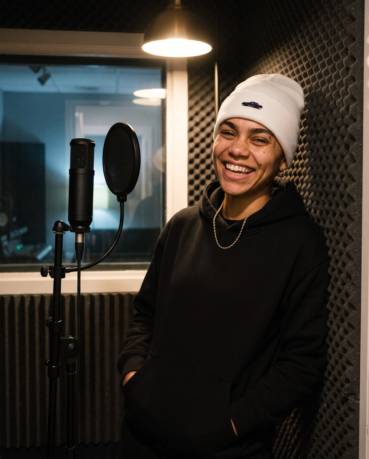 Model wearing the GNX Inspired Beanie in White, in a vocal booth