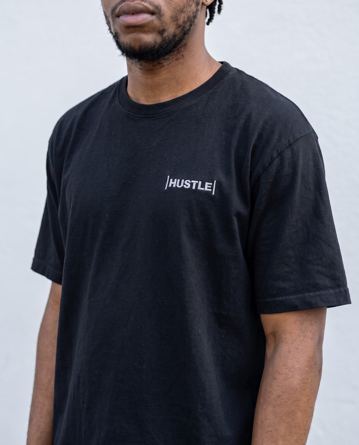 Model wearing the Hustle t-shirt in Black, print close-up