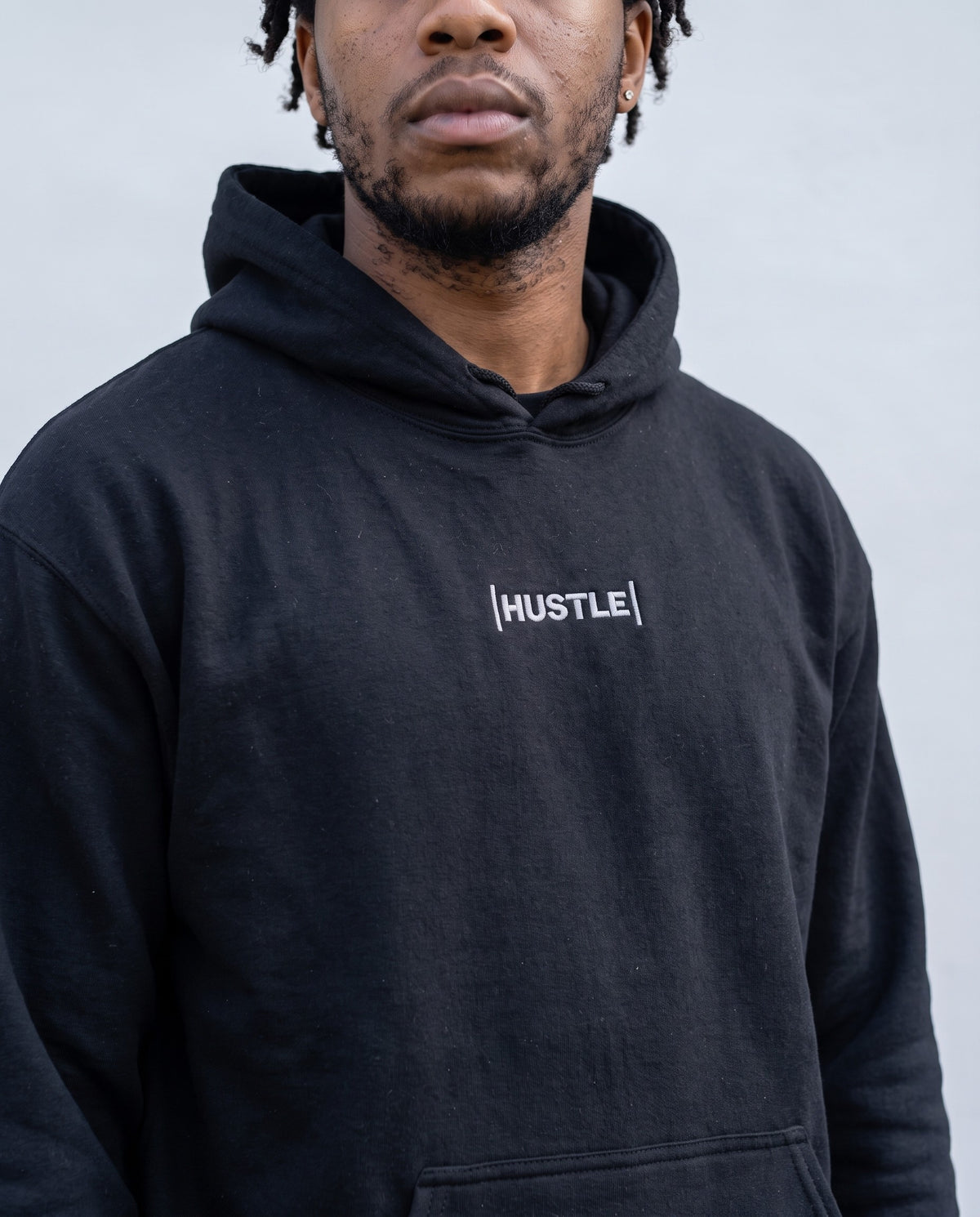 Model wearing the Hustle Hoodie in Black, print close-up