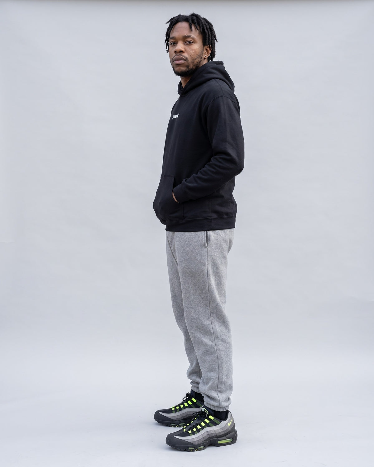 Model wearing the Hustle Hoodie in Black, side profile