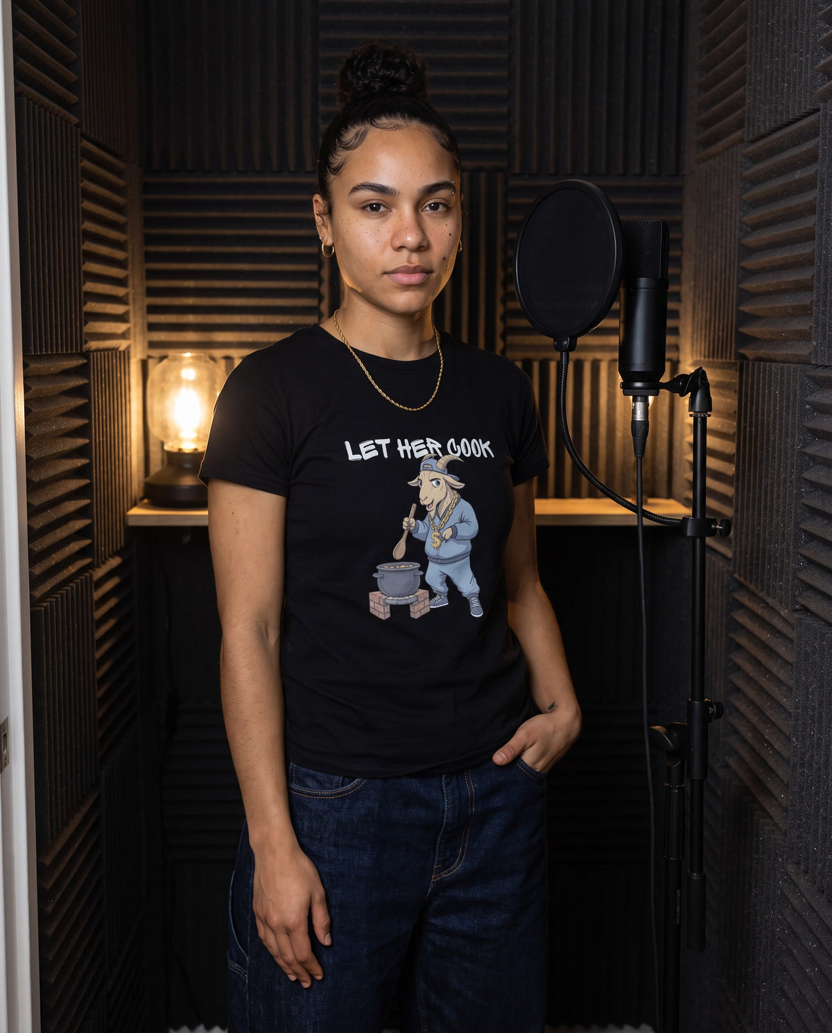 Model wearing the Let Her Cook t-shirt in Black, in a vocal booth