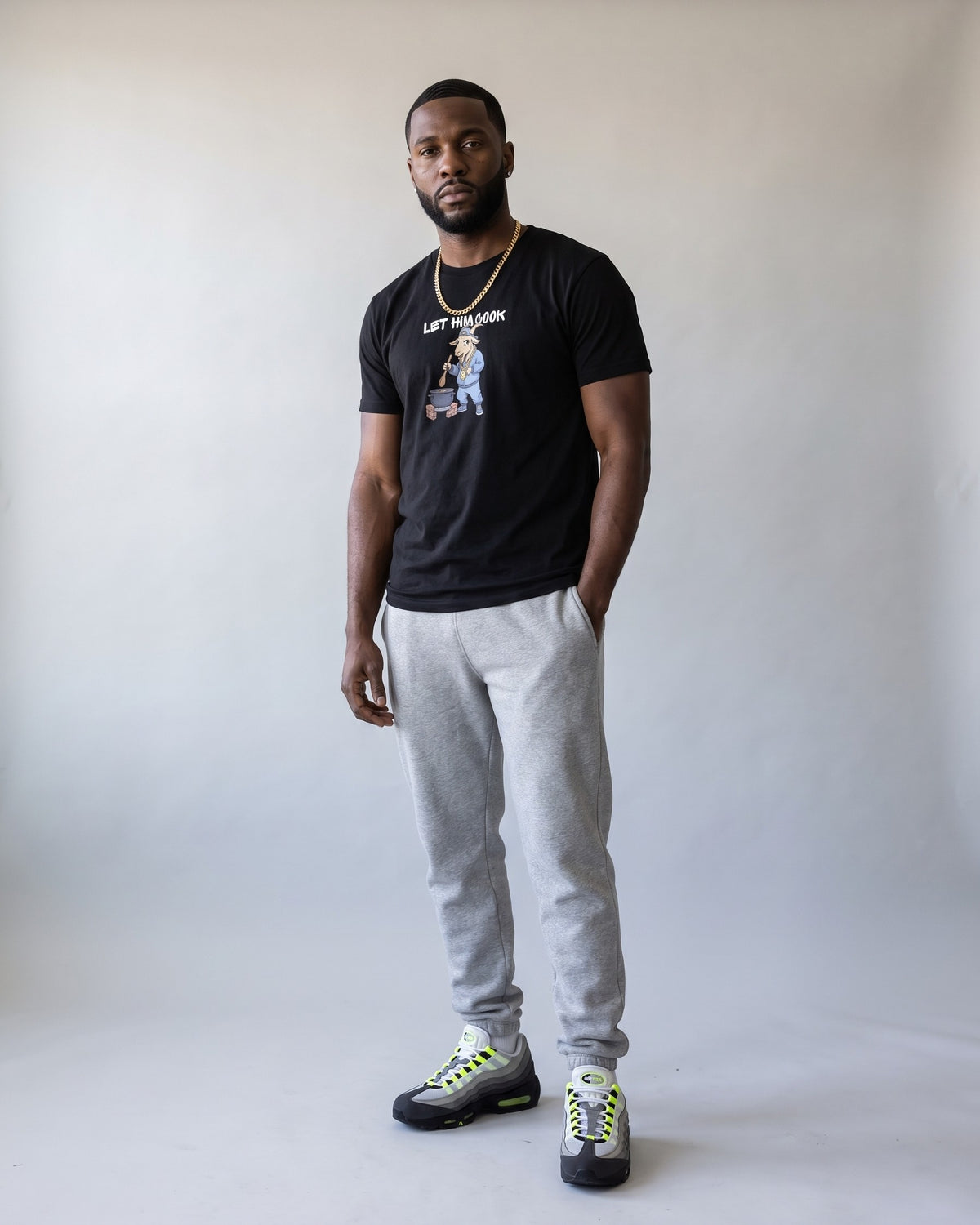Model wearing the Let Him Cook t-shirt in Black, full length