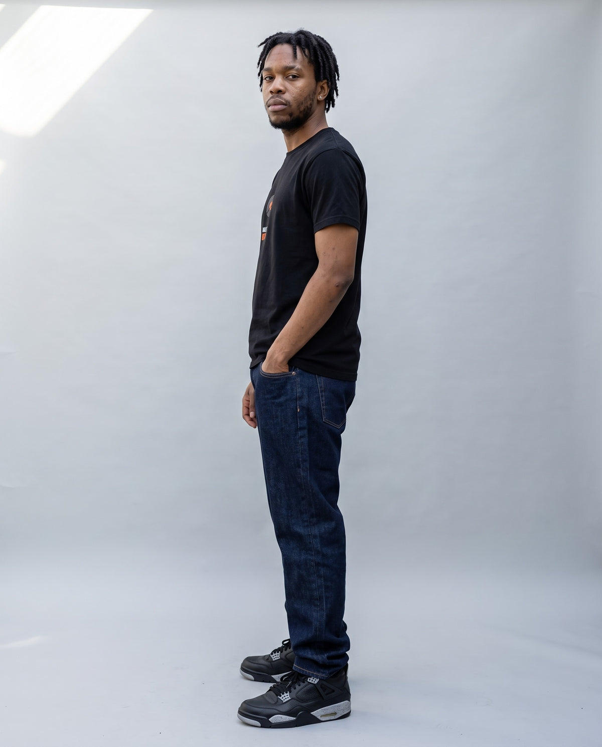 Model wearing the Make Beats Not War t-shirt in Black, side profile