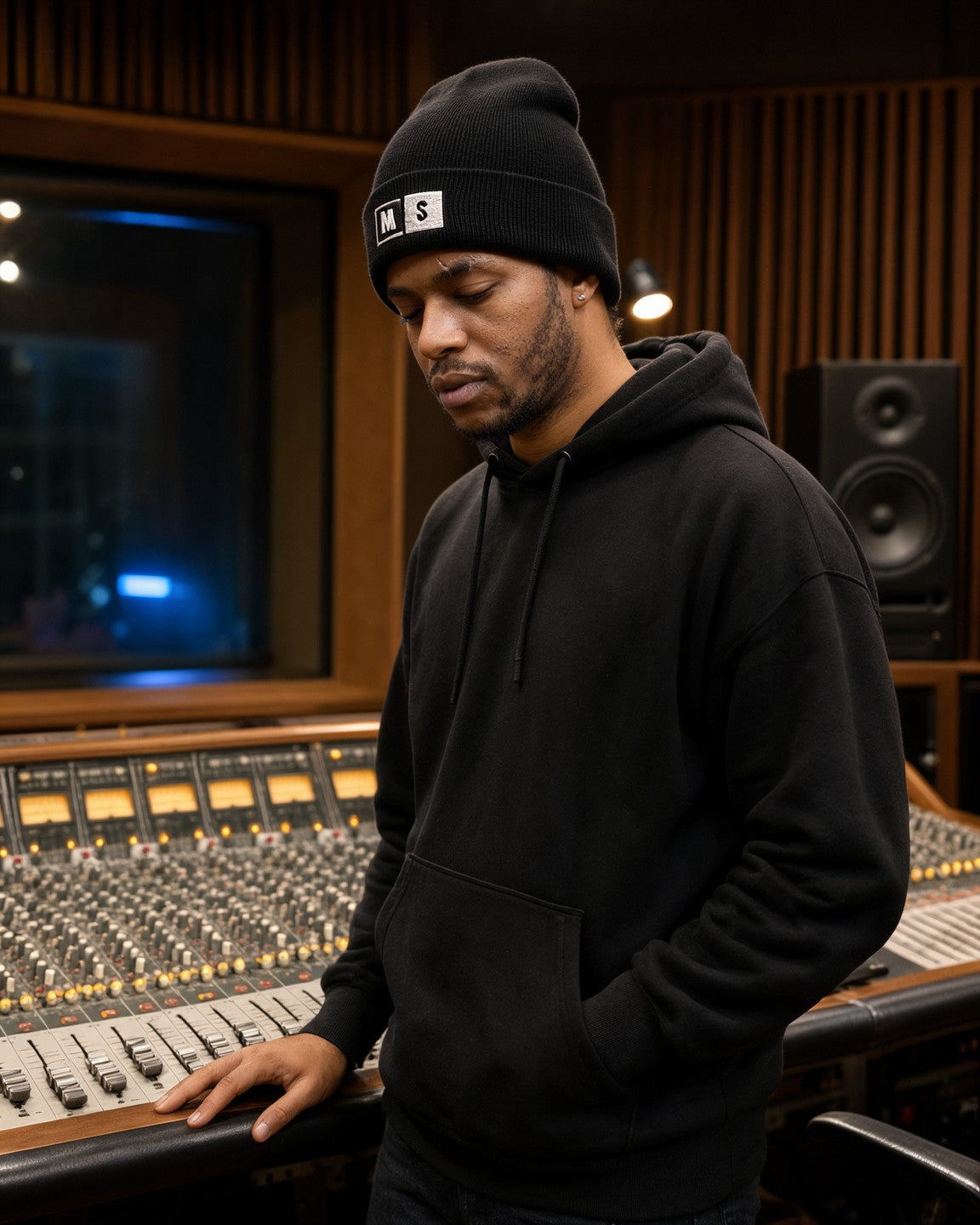 Man wearing the Mute / Solo hip hop beanie in black, standing at a studio console