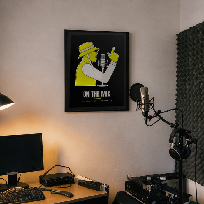 On The Mic Studio Poster framed on a home studio wall beside a vocal mic