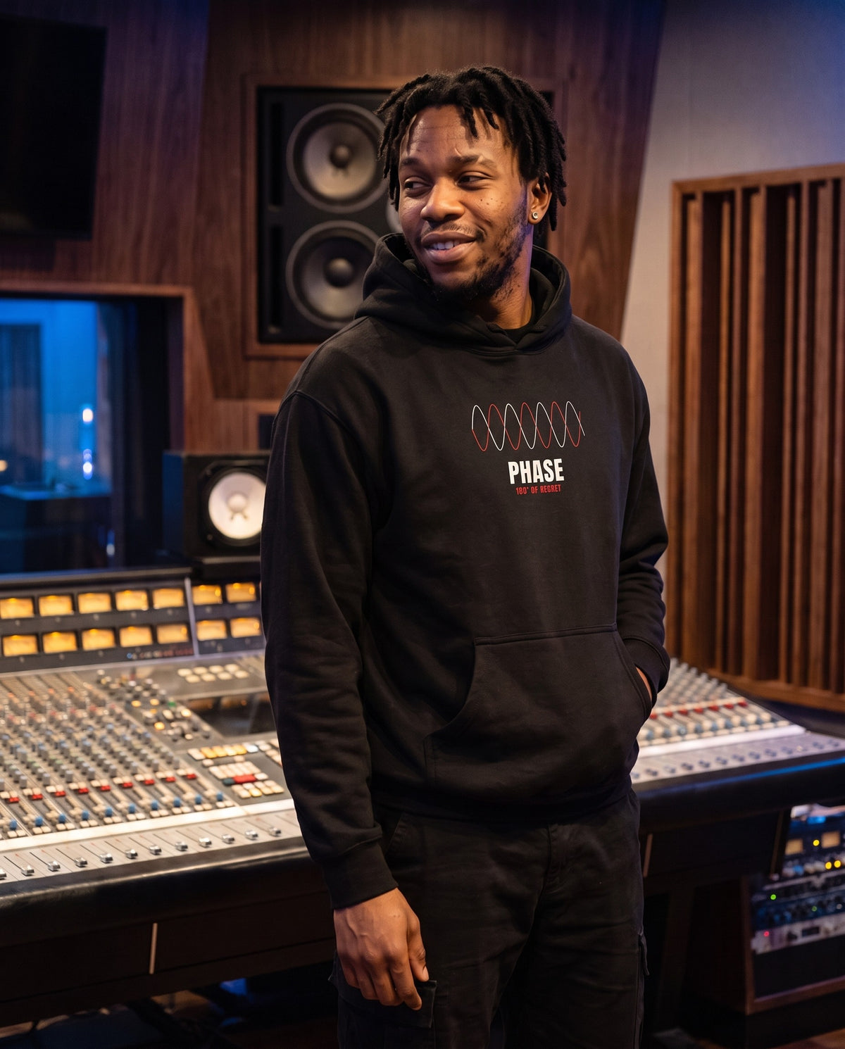 Model wearing the Phase hoodie in Black, in a recording studio control room