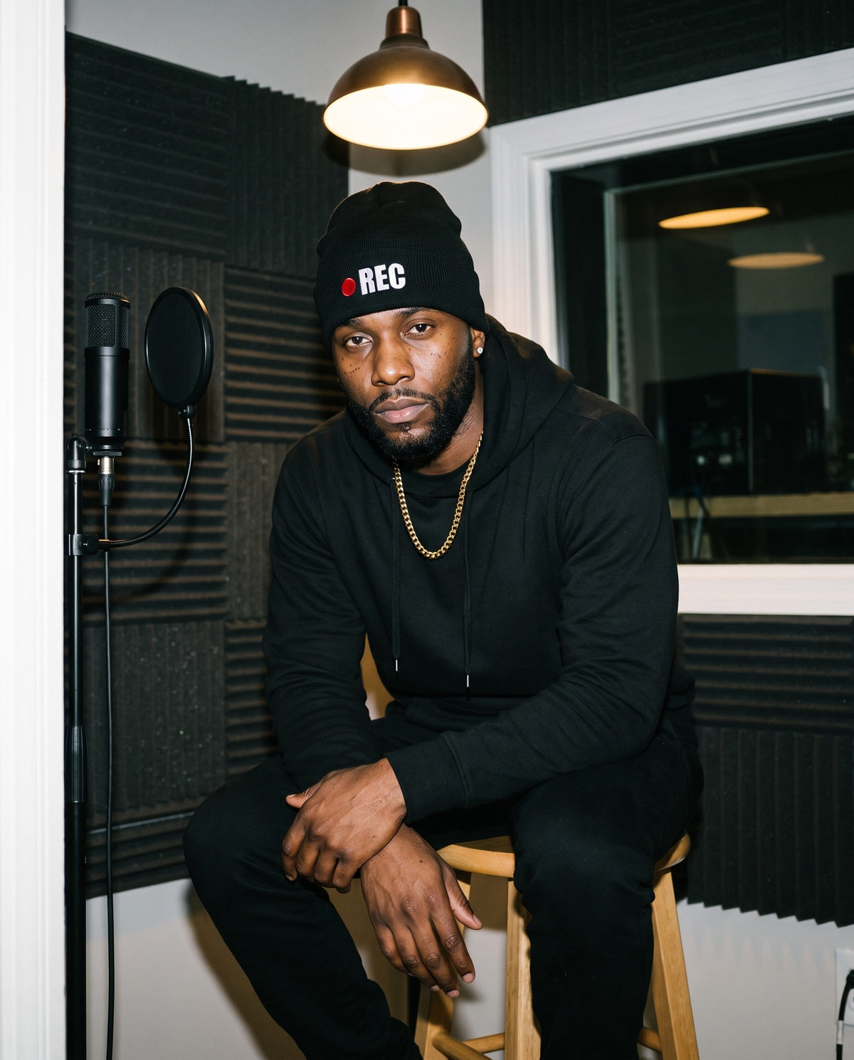 Model wearing the REC beanie in Black in a vocal booth