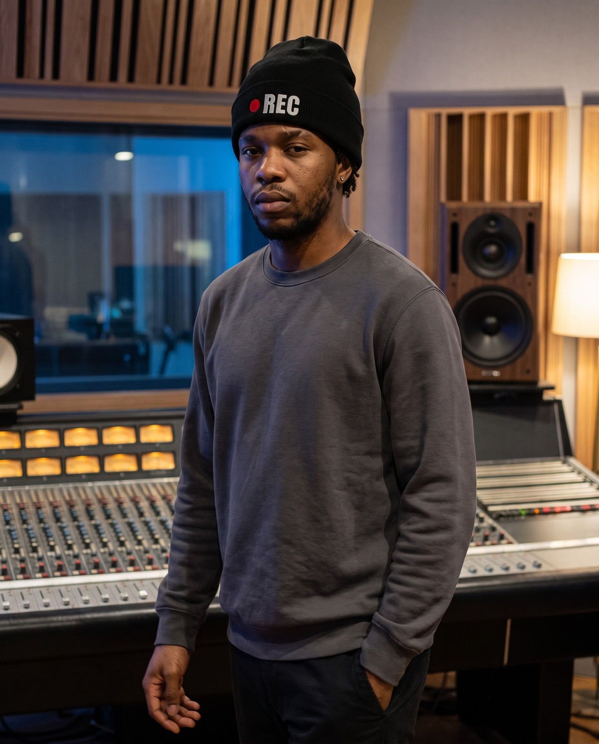 Model wearing the REC beanie in Black in a recording studio control room