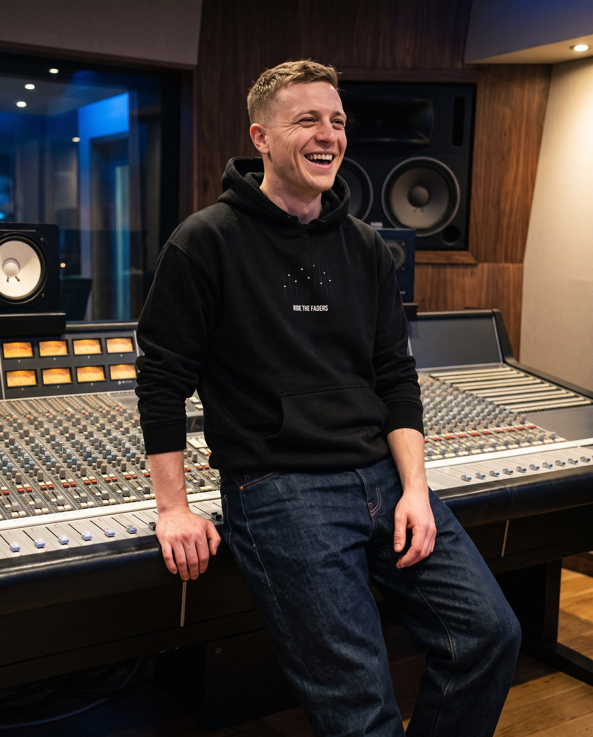 Model wearing the Ride The Faders hoodie in Black, in a recording studio control room