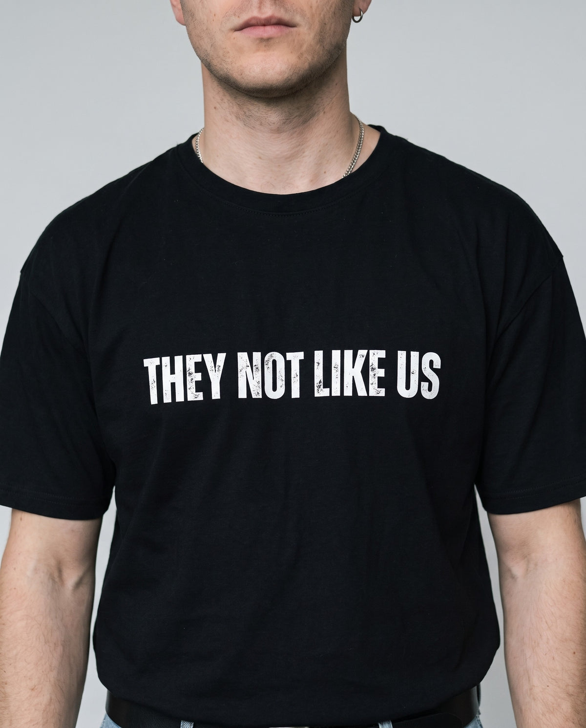 Model wearing the They Not Like Us t-shirt in Black, print close-up