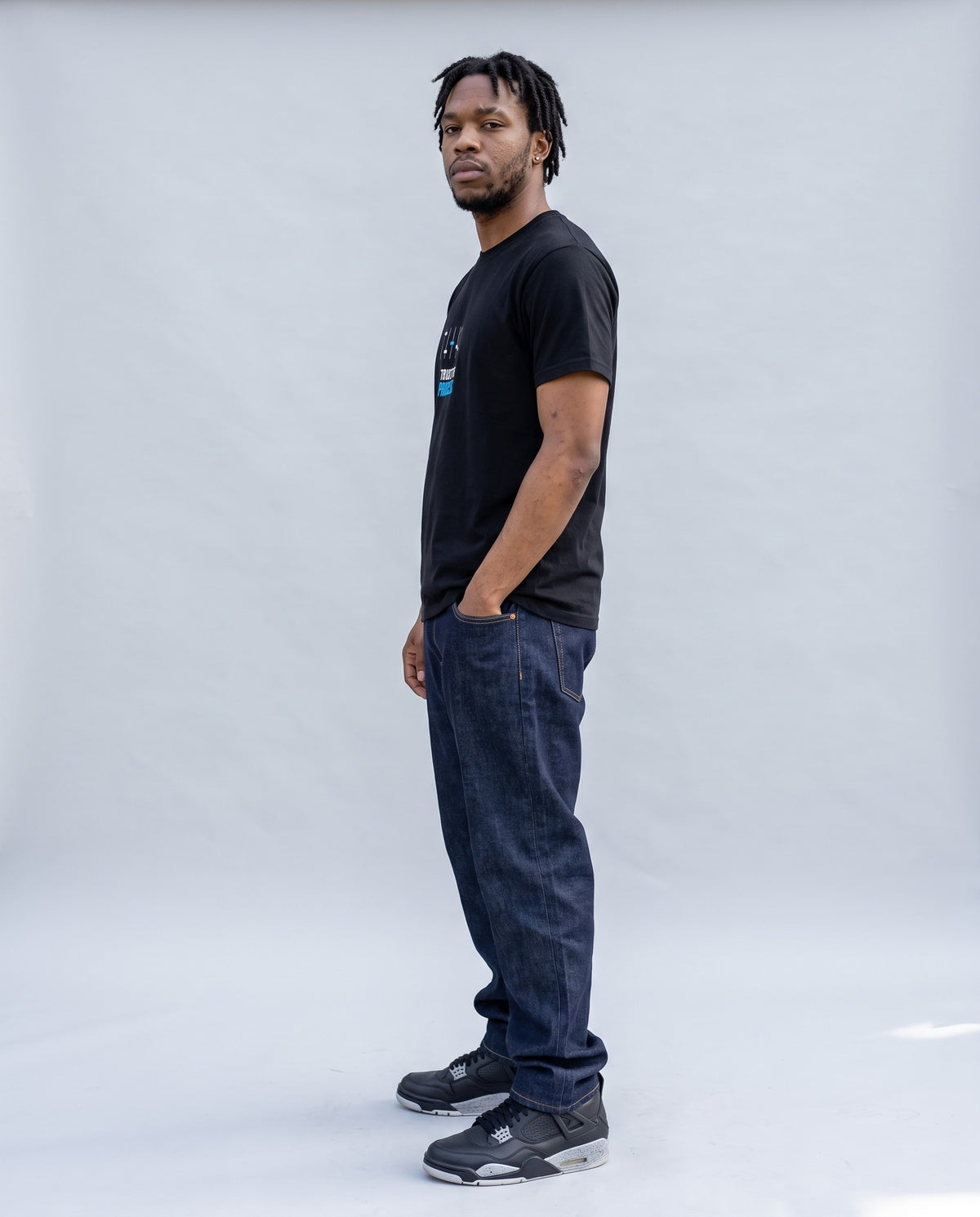 Model wearing the Trust The Process t-shirt in Black, side profile